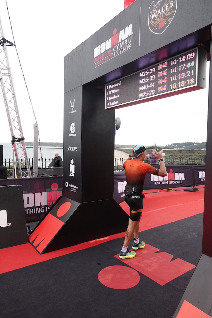 Ironman Wales finisher Dominic Taylor crossing the line