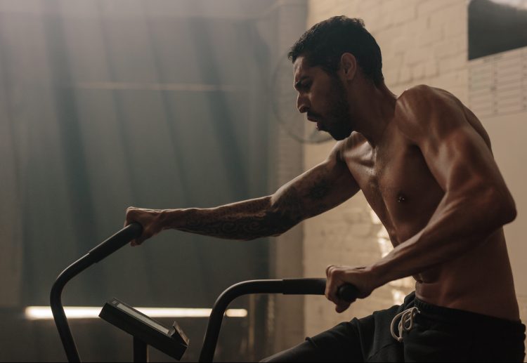 A close-up of a man exercising on an air bike