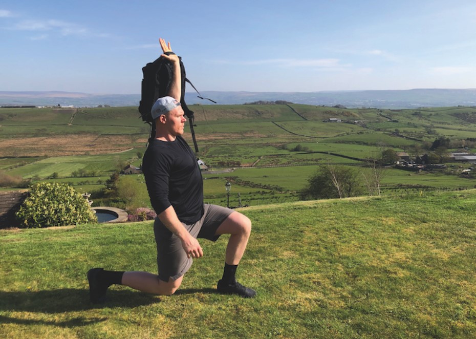 Man performing an overhead lunge with a backpack