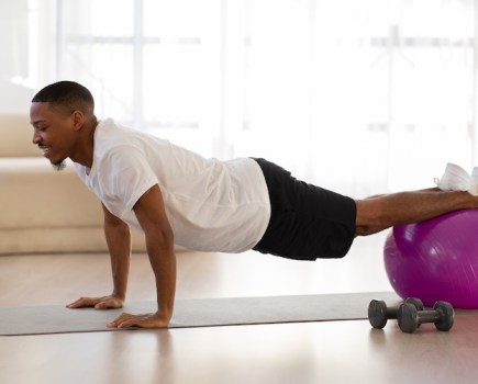 Man using an exercise ball at home