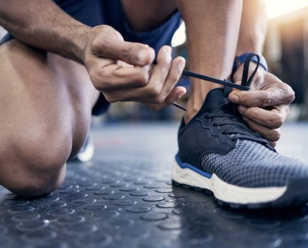 Close-up of a man tying his gym shoes