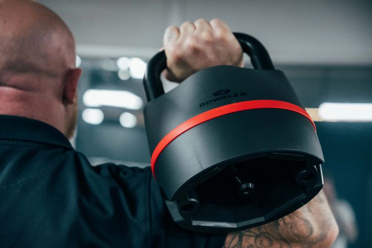Close-up of a man lifting a Bowflex adjustable kettlebell