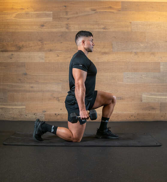 suitcase hold split squat; holding a dumbbell in each hand, man lunges with knees at 90 degrees