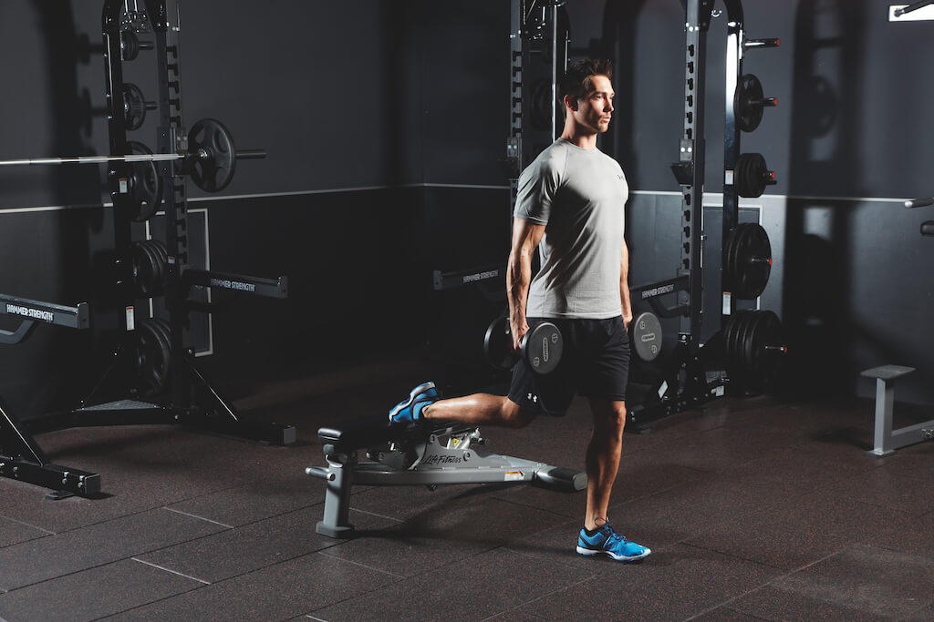 man demonstrating dumbbell bulgarian split squat in AMRAP workout
