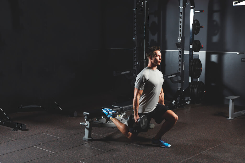 man demonstrating dumbbell bulgarian split squat in AMRAP workout