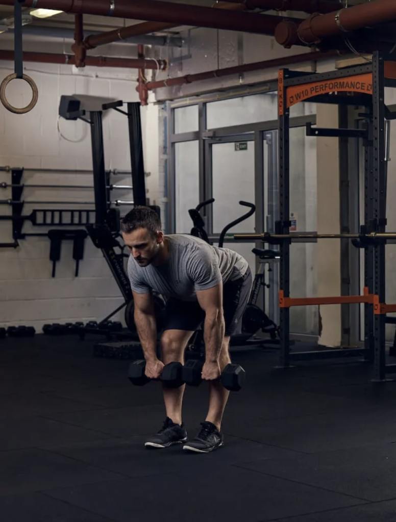 man performing dumbbell Romanian deadlift
