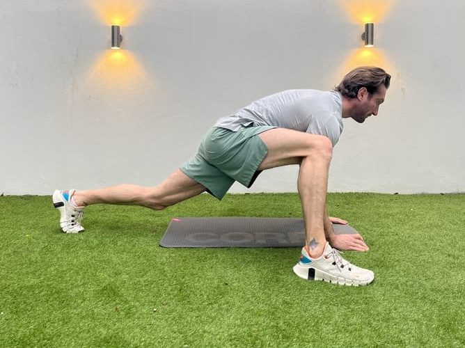 man demonstrates how to perform dynamic spiderman stretches exercise