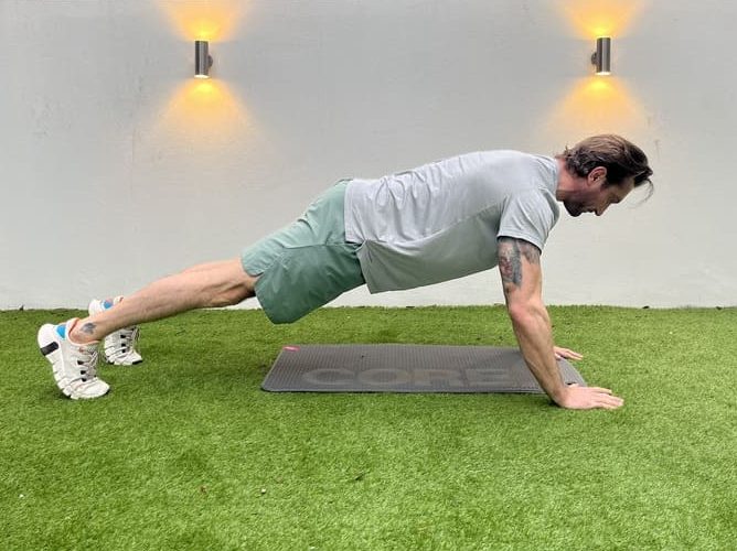 man demonstrates dynamic pigeon stretch