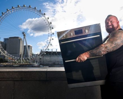 Strong man lifting an over, with the London Eye in the background