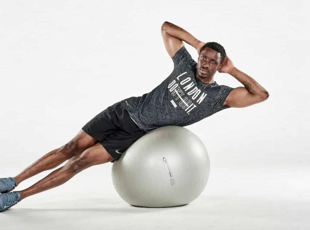 Man performing an exercise ball oblique crunch