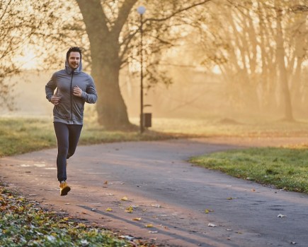 Male jogger in the park on sunny autumn morning