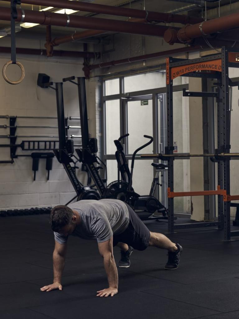 man demonstrates part 3 of half burpee
