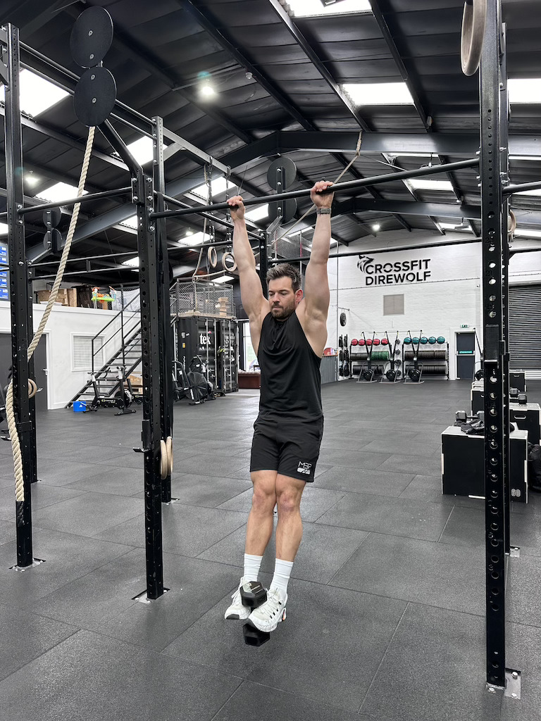PT showing how to do a hanging weighted knee raise