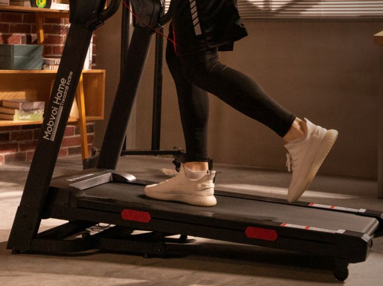 The lower torso of a man running on the Mobvoi Hone Treadmill Incline