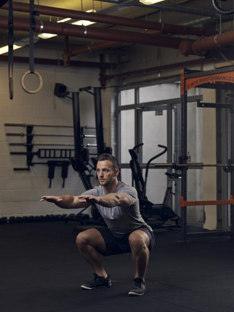 man demonstrates air jump squat