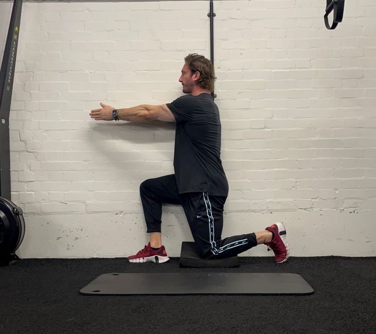 Man performing half kneeling windmill - best back stretches