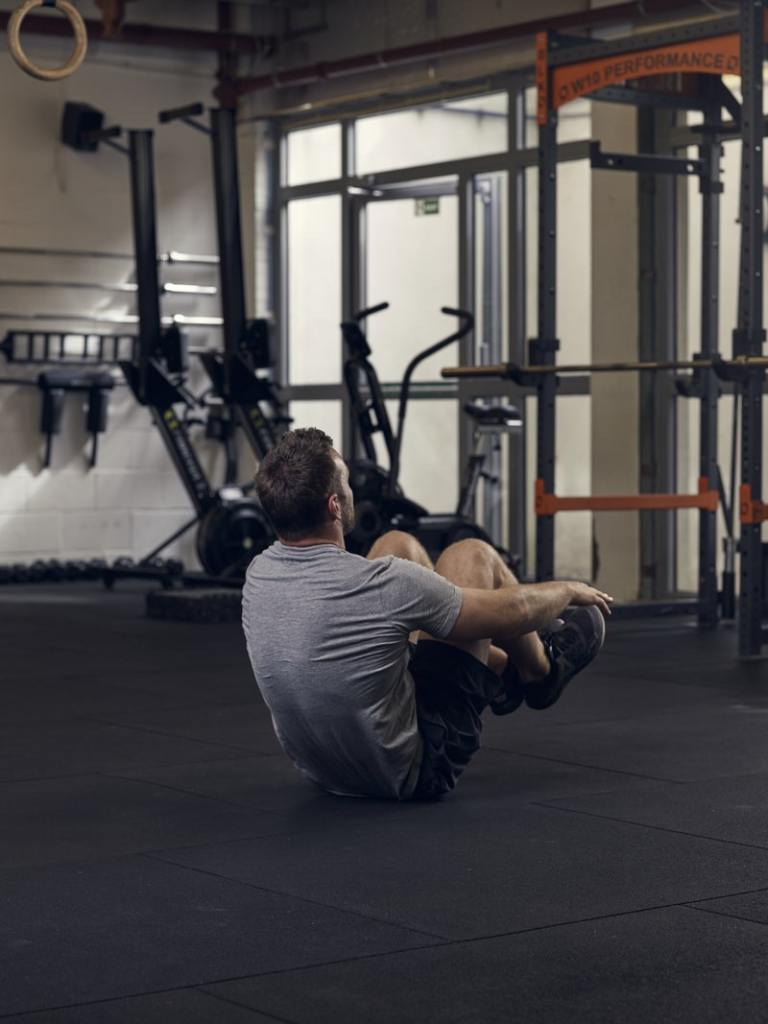 man demonstrates pike crunch, one of the best bodyweight exercises for core strength