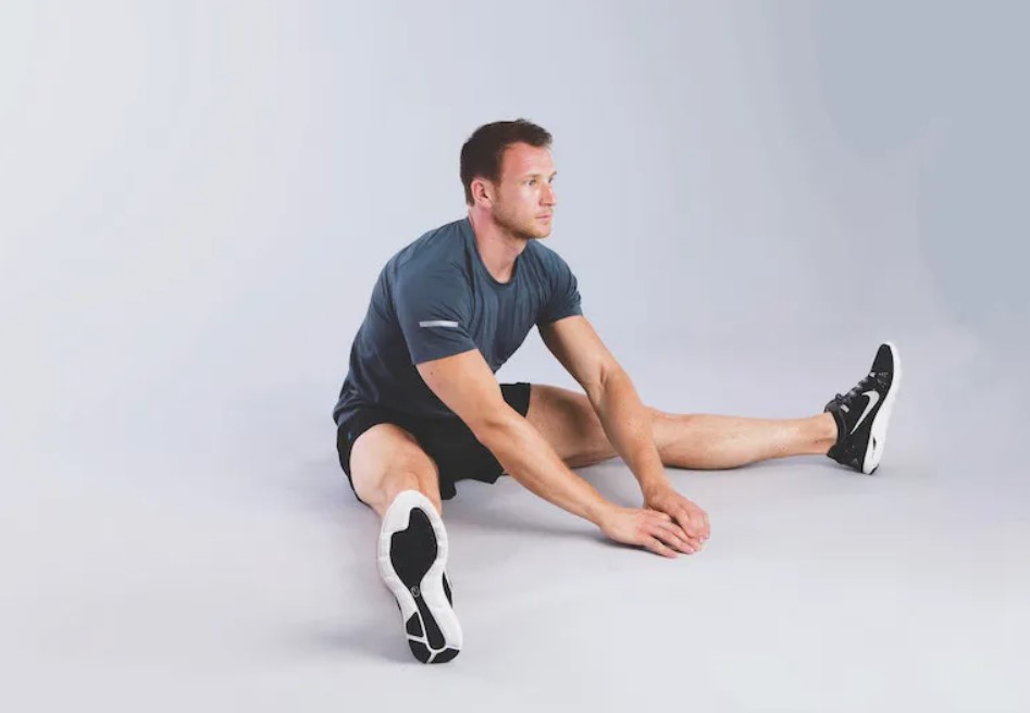Man performing a rolling saddle stretch