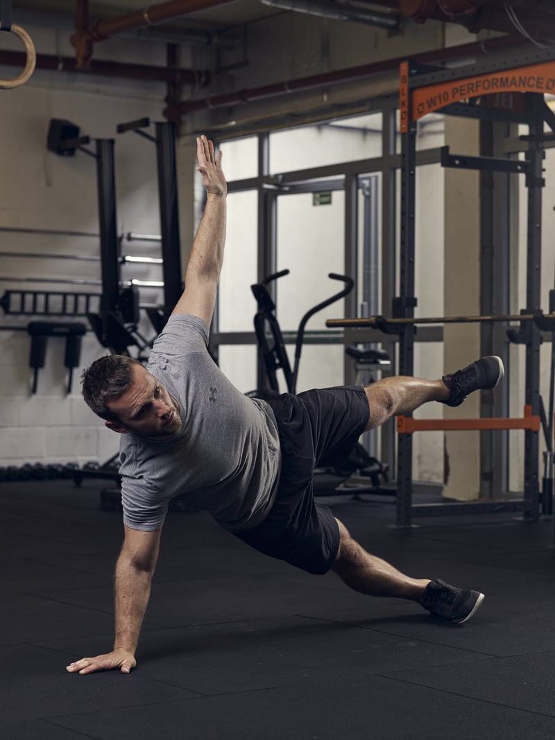man demonstrates side plank star, one of the best advanced bodyweight exercises for core strength