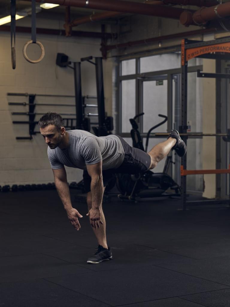 man demonstrates single leg romanian deadlift, one of the best bodyweight exercises for lower body strength