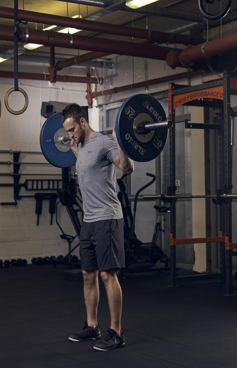man demonstrating barbell squat