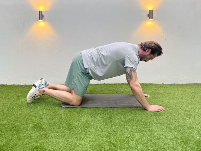 man demonstrates step one in the thread the needle stretching exercise