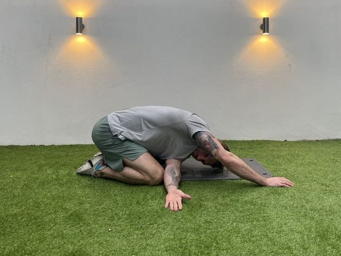 man demonstrates thread the needle stretch in garden